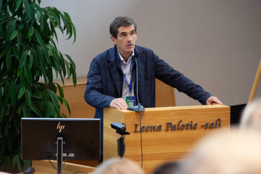 Joan Guanyabens delivering the opening keynote at a lectern